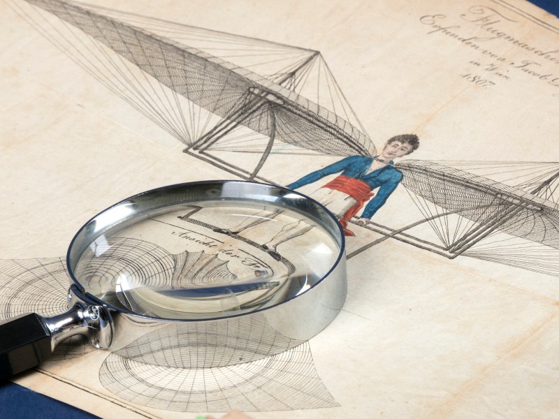 Magnifying glass on a coloured drawing of a flying machine by Jakob Degen from 1807: 